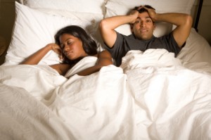 Stressed out man as woman sleeps