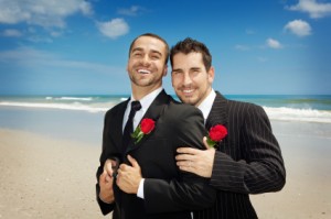 Two gay men holding each other on a beach getting married