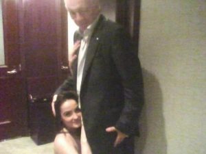 brunette woman kneels in front of Jerry jones