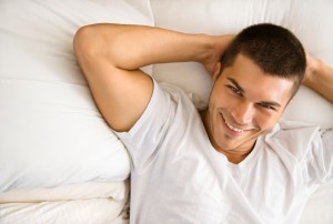 A happy man lies in bed