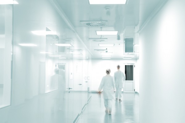 Two people walk down a hospital corridor