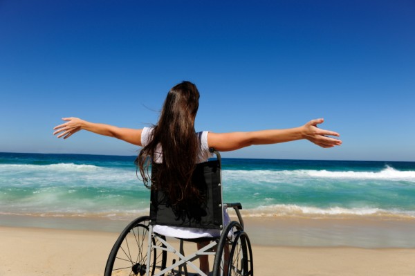 woman in wheelchair enjoying summer vacation on the  beach