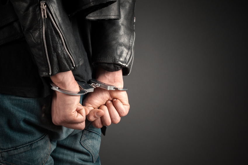 Man in leather jacked in hancuffs