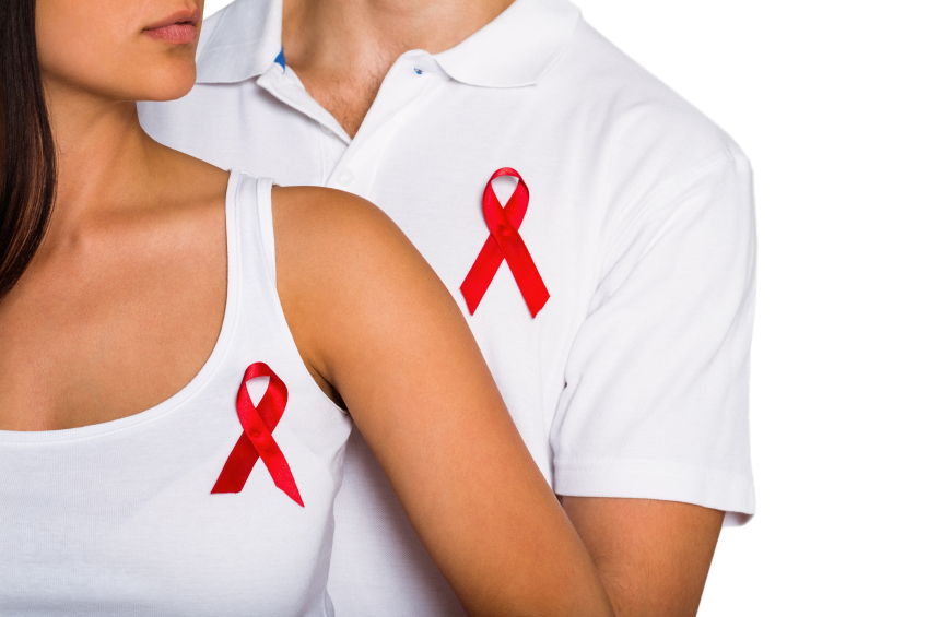 A man and a woman dressed in white with the HIV/AIDS awareness ribbons on their t-shirts