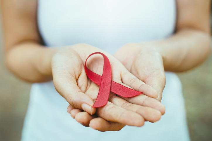 red aids ribbon in hand. soft focus on ribbon