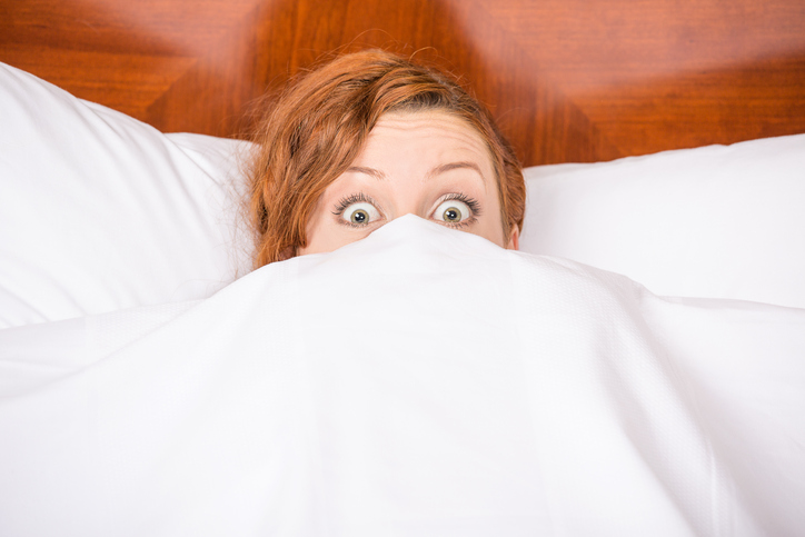 Shocked woman in bed