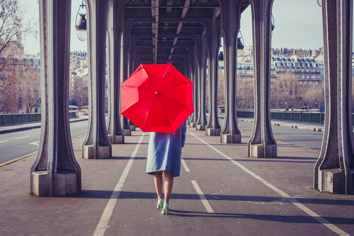 fashion woman with red umbrella walking on the street in Paris