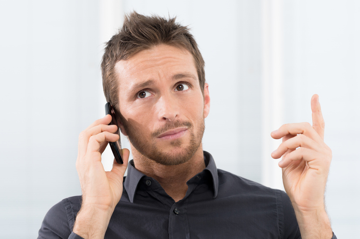 Businessman Listening Seriously On Mobile Phone In Office