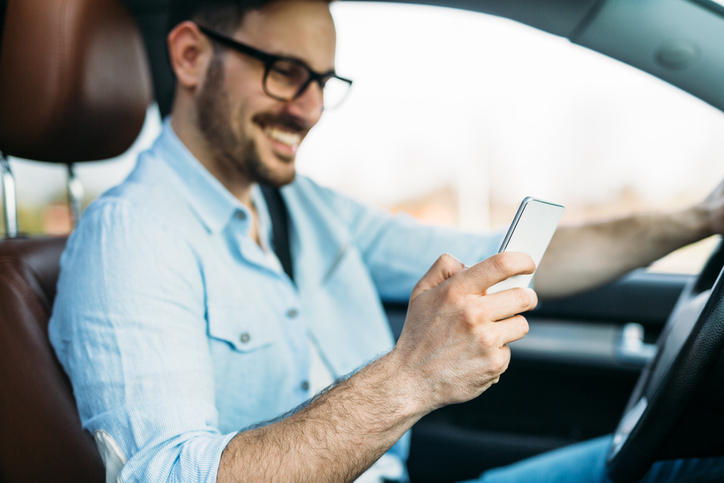 transportation concept - man using phone while driving the car