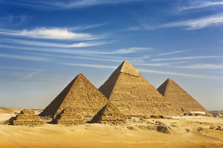 "Egypt. Cairo - Giza. General view of pyramids from the Giza Plateau (there is three pyramids popularly known as Queens' Pyramids on front side; next in order from left: the Pyramid of Menkaure /Mykerinos/, Khafre /Chephren/ and Chufu /Cheops/ - known as the Great Pyramid). The Pyramid Fields from Giza to Dahshur is on UNESCO World Heritage List"