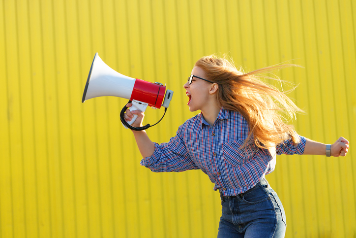 Girl feminist shouts in loudspeaker